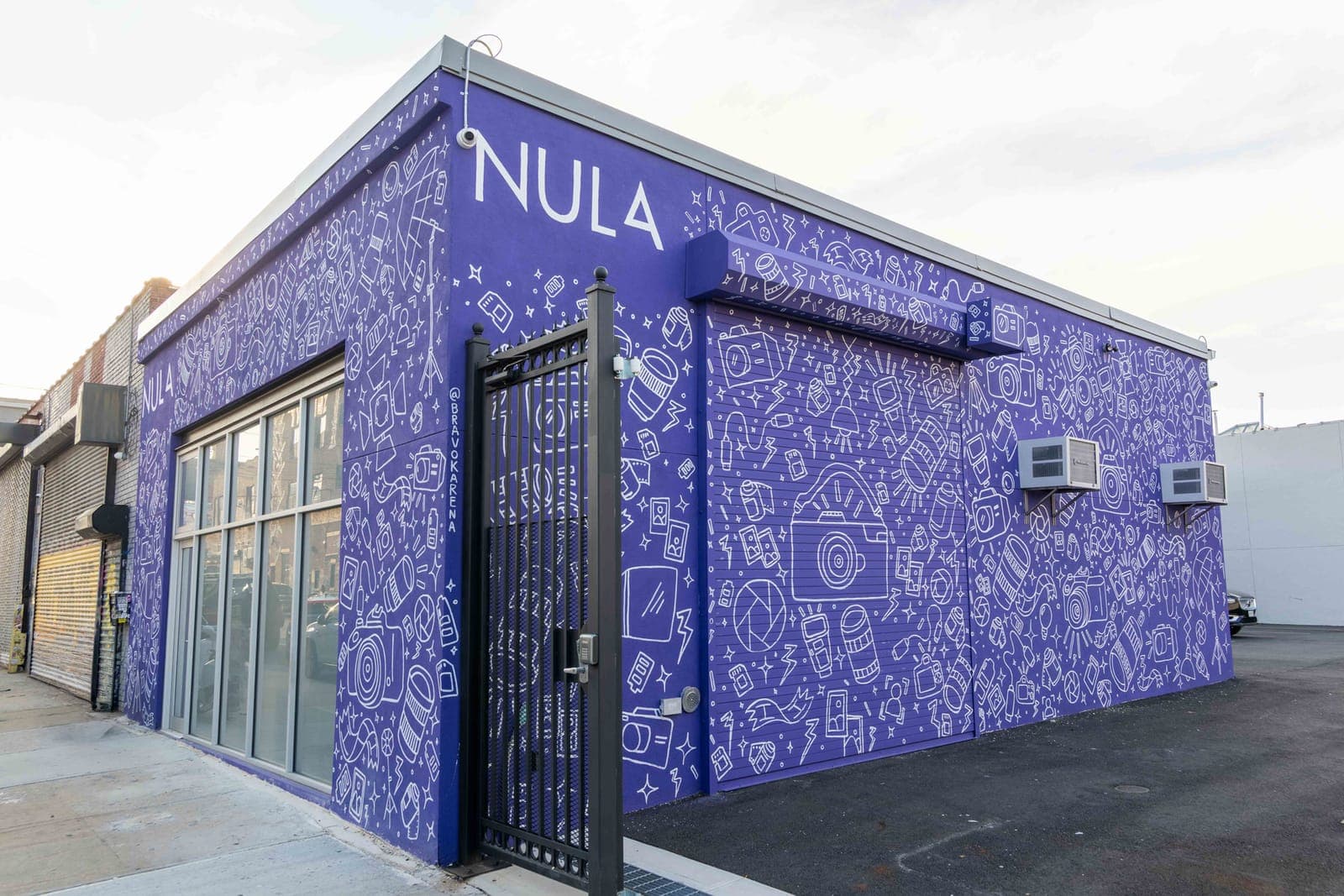 The Studio Nula building in Brooklyn, painted purple with a white hand-drawn camera mural
