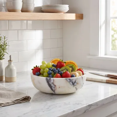 The same marble bowl full of fruit on a kitchen counter
